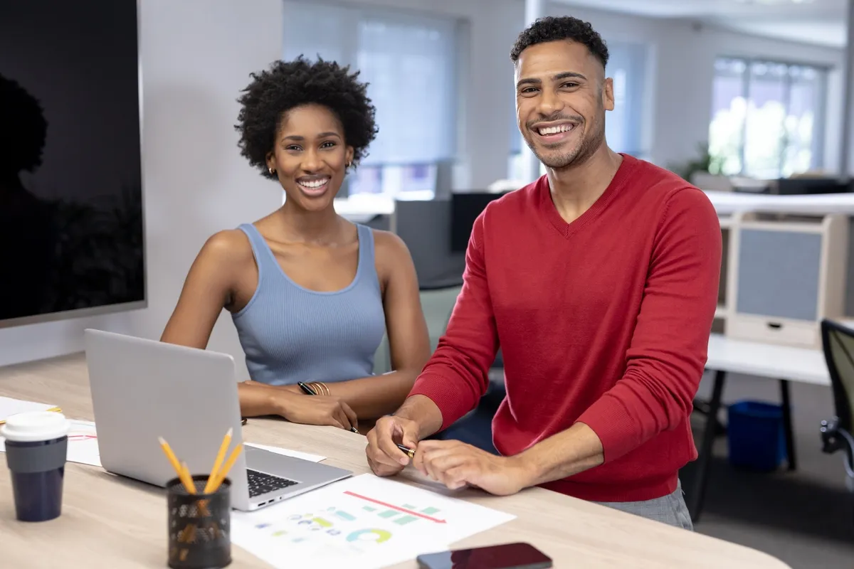 IT consultant working at desk with business woman